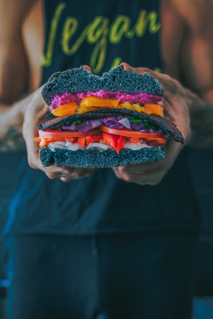 woman holding vegan sandwich with vegan apron