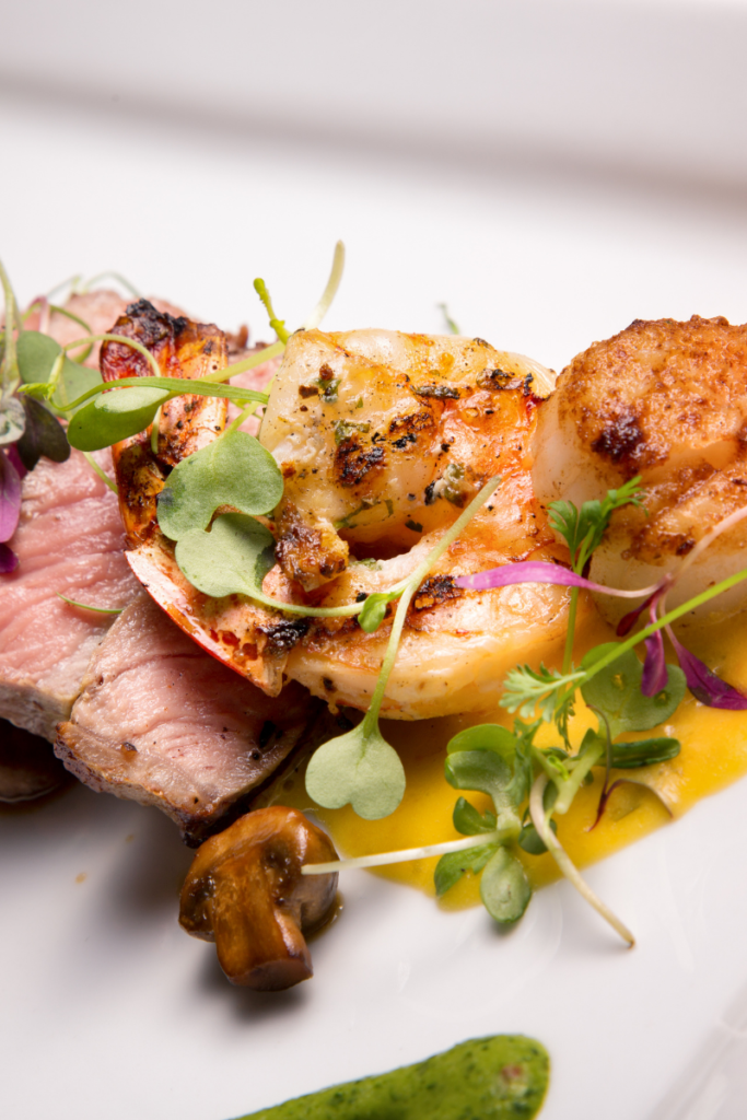 Shrimp on white plate with herbs and greens